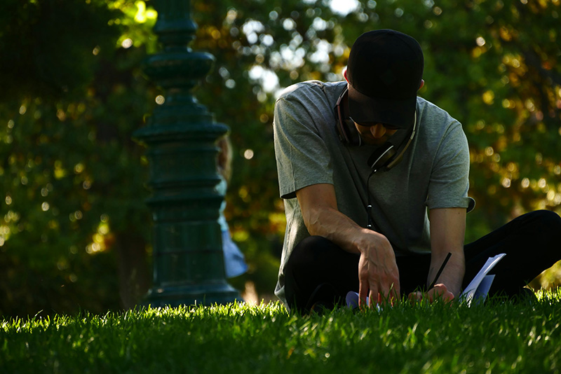 Man journalling in a park wellbeing